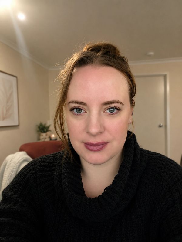 Woman with blue eyes and brown hair in a black sweater.