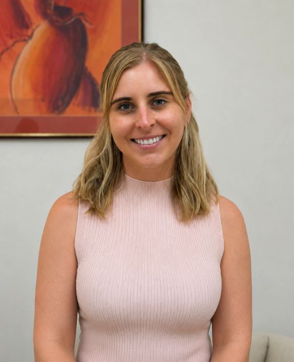 Smiling woman with blonde hair in a sleeveless top.