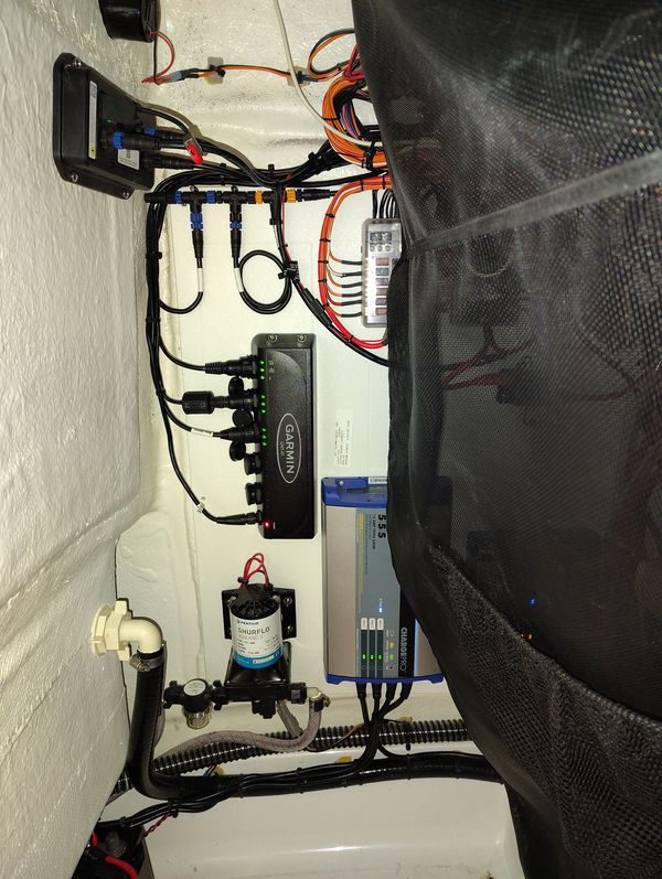 Organized marine electrical and electronic setup with Garmin devices and wiring.