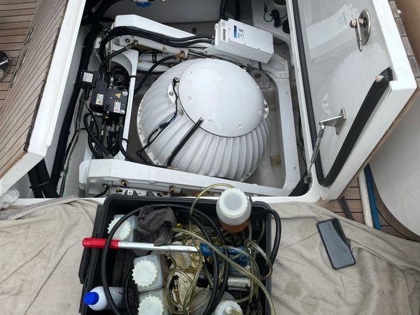 Open compartment on a boat with mechanical equipment and tools.