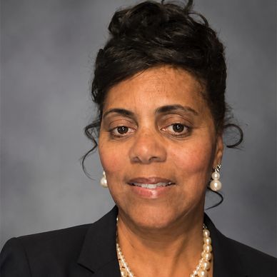 Professional woman wearing pearl jewelry and business attire.