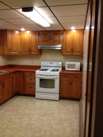 Vintage kitchen with wooden cabinets and white stove.