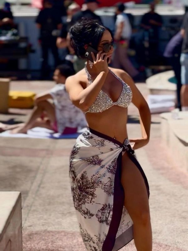 Woman in stylish swimwear talking on phone at poolside.