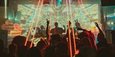 Crowd enjoying a vibrant club with laser lights.