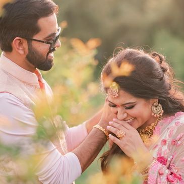 A couple sharing a tender moment in traditional attire outdoors.