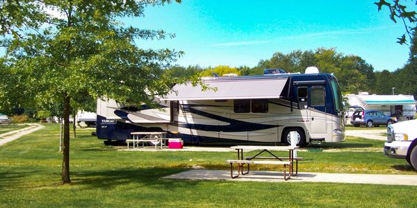 Motorhome parked in camping spot with awning extended.