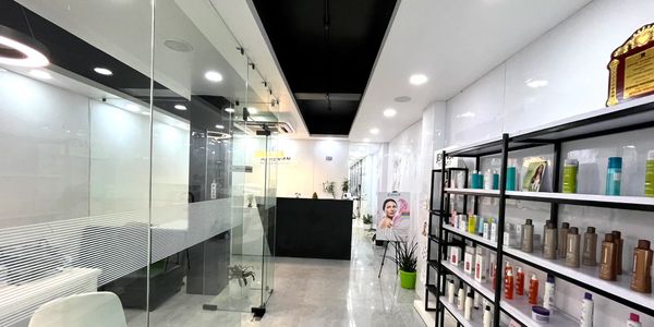 Modern salon with glass walls and beauty products on display shelves.