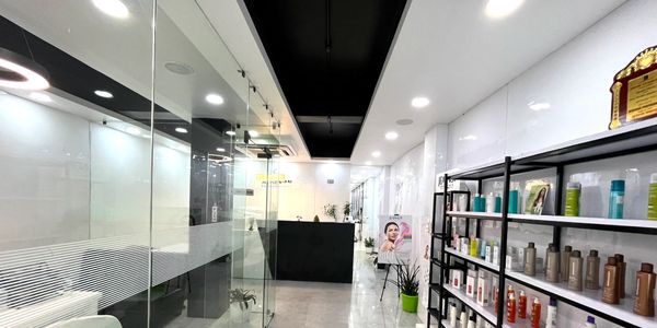 Modern salon with glass walls and beauty products on display shelves.