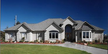 Spacious custom brick ranch home with welcoming towering porch by Kraus Plans
