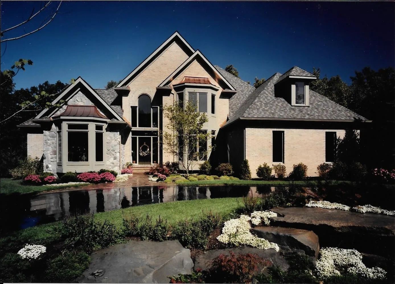 Custom home exterior with landscaped front yard by Kraus Design Build and Kraus Plans