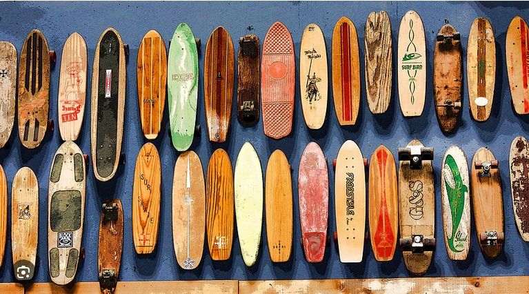A collection of vintage wooden skateboards mounted on a blue wall.