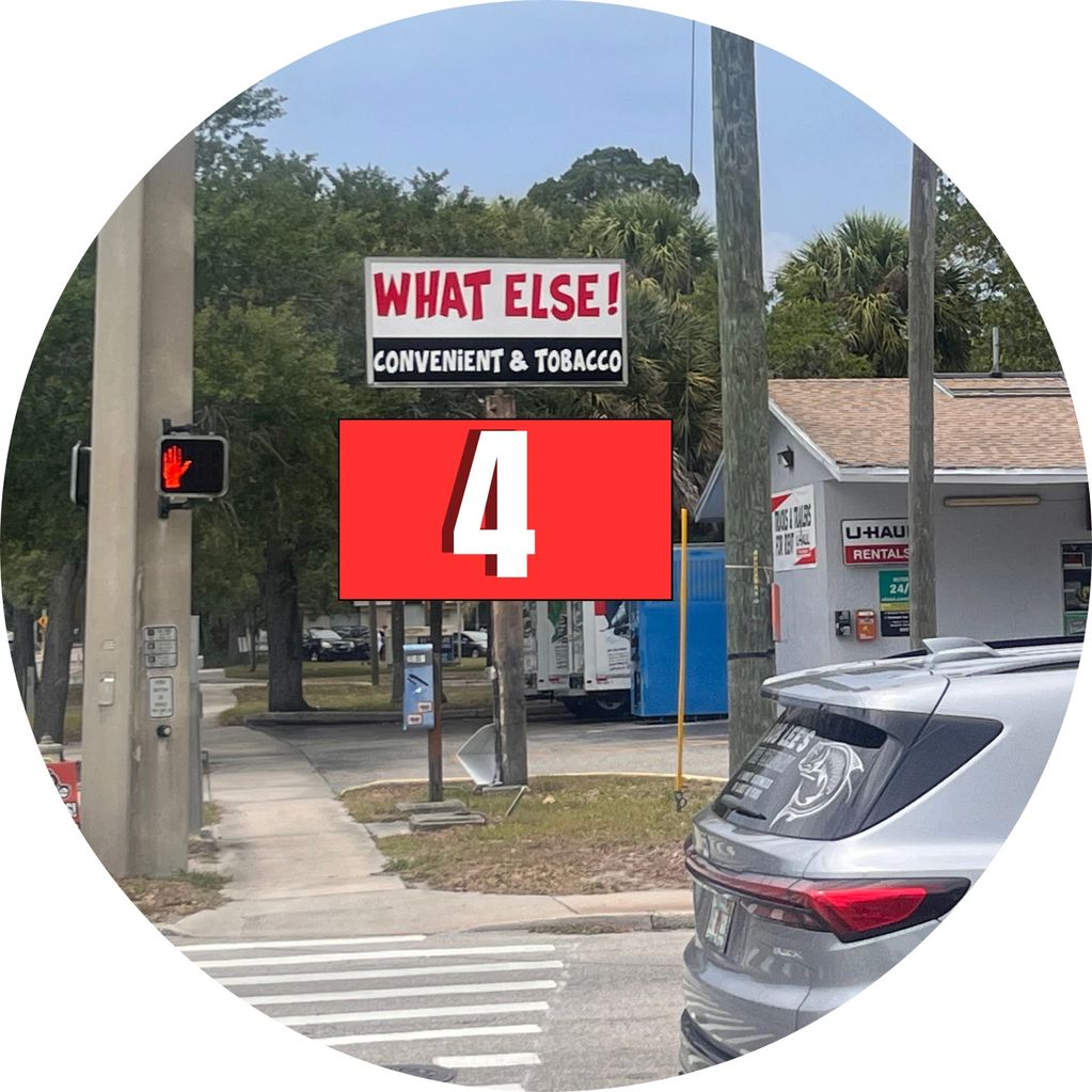 Street view showing a convenient store sign and a pedestrian stop signal.