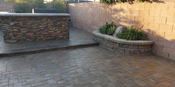 Anaheim hardscape paver patio with raised planter and outdoor BBQ island