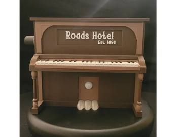 Miniature piano model labeled 'Roads Hotel Est. 1893'.