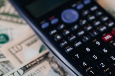 Close-up of a calculator on US dollar bills.