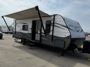 Travel trailer with extended awning in a parking area.