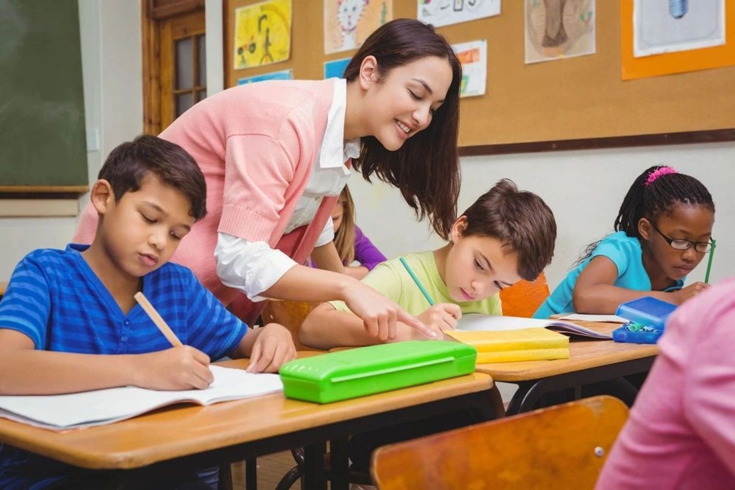 Teacher helping students in a classroom.
