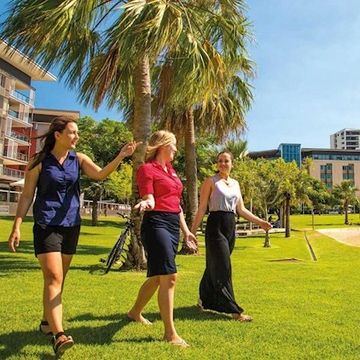 Three women walking on grass