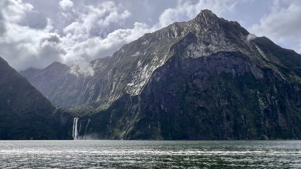 Waterfall and mountain in fjord, Milford Sound cruise, Fiordland National Park, New Zealand
