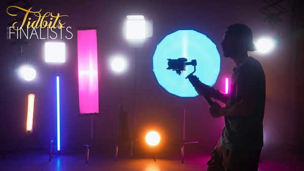 Videographer silhouetted against colorful studio lights.