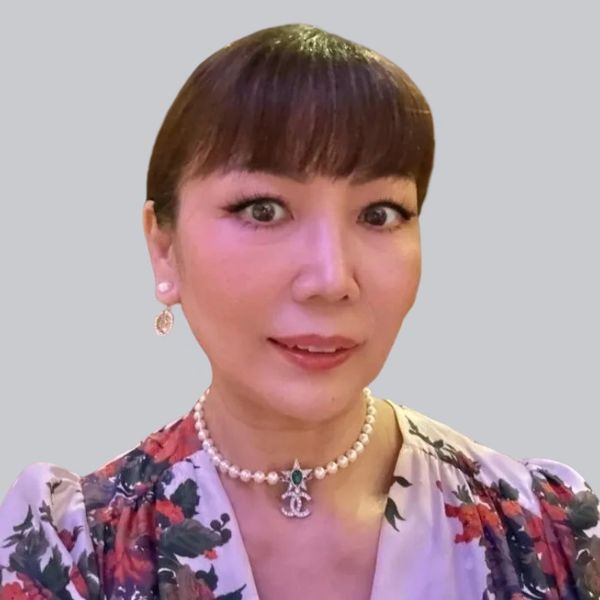 Portrait of a woman with pearl necklace and floral dress.