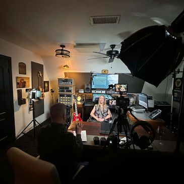 A music recording session with a woman and a man in a studio.