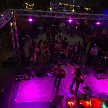 Live band performing on stage at night with an audience.
