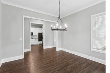 Empty dining room with wooden floor and modern chandelier.