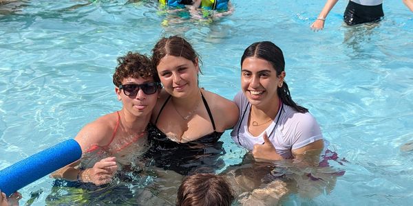 kids swimming in an outdoor pool at camp