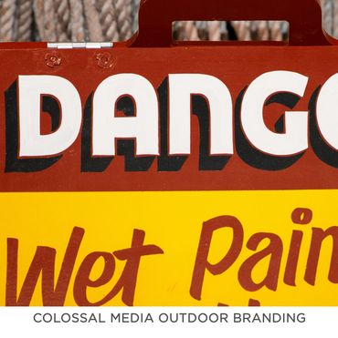 Close-up of a sign reading 'Wet Paint' under the word 'DANGO'.