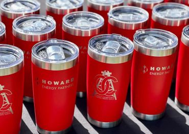 Red insulated tumblers with Howard Energy Partners logo.