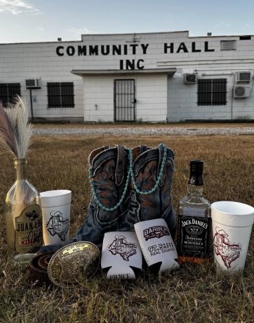 Cowboy boots and drinks in front of a community hall.