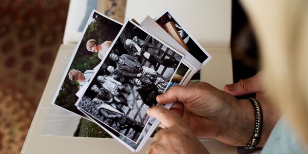 A close up of a woman's hands holding a collection of old photographs