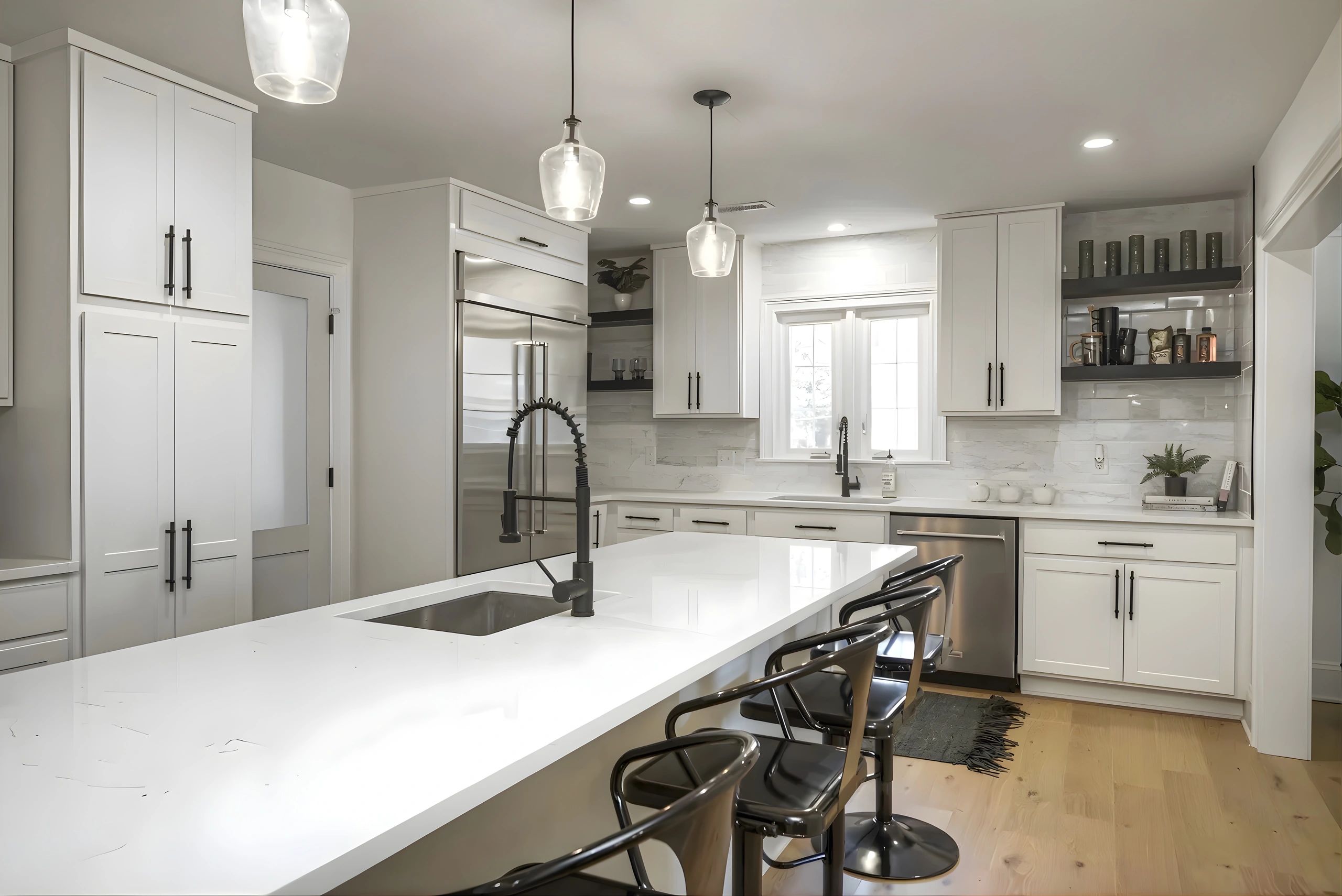 Modern white kitchen with island and metal bar stools.