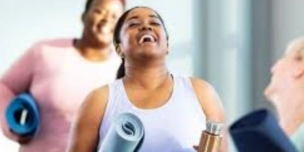 a woman laughing with a mat in her hand 