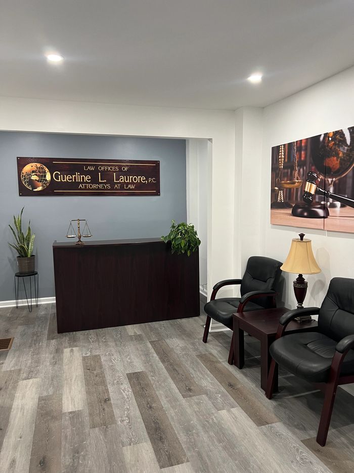 Modern law office reception with dark wood desk and leather chairs.