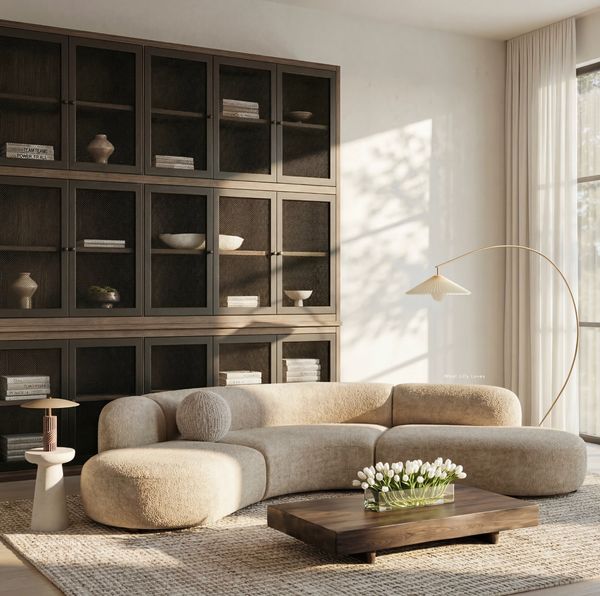Cozy modern living room with beige curved sofa and wooden coffee table.