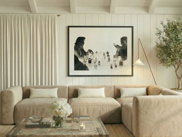 Cozy beige sectional sofa with art and plants in a stylish living room.