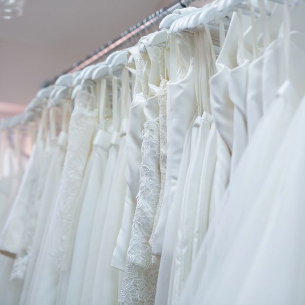 Satin, lace and tulle wedding dresses, bodices and skirts hung on chrome rail in my workroom