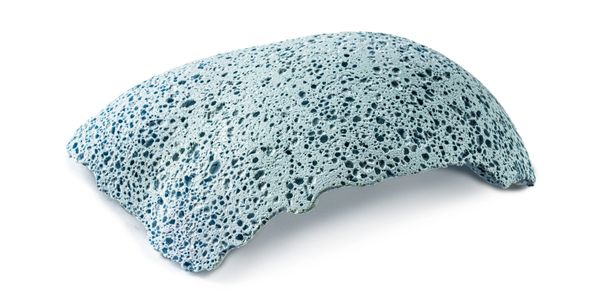 A porous, curved blue object resembling pumice or foam.