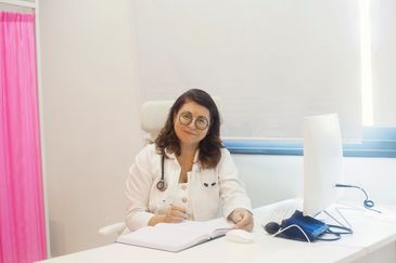 Female doctor sitting at desk with a notebook.