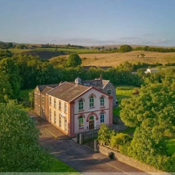 A large house surrounded by greenery and countryside.