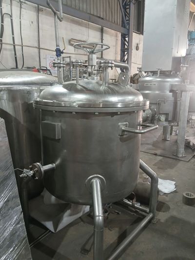 Industrial stainless steel mixing or processing tank.