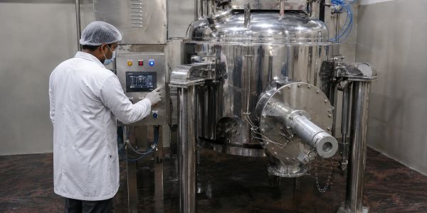 Technician operating a stainless steel industrial machine.