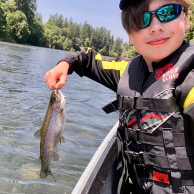 Young boy holding a fish on a boat.