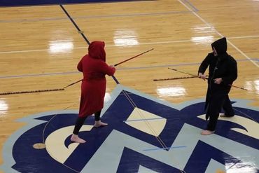 Two karate / martial arts / Tang Soo Do students demonstrating with bo staffs