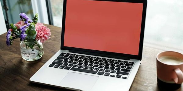 Computer with coffee and flowers 