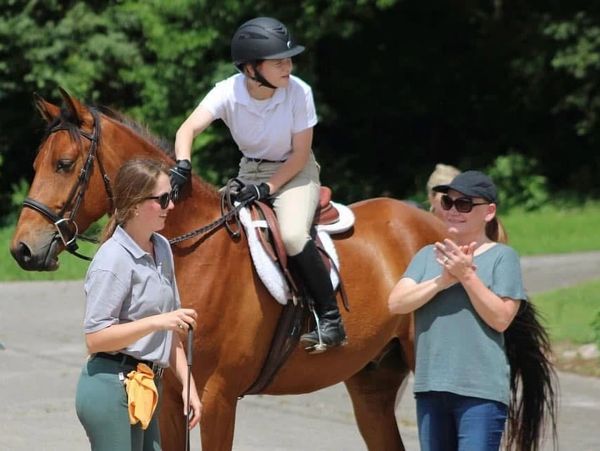 A rider and lesson student at a horse show.