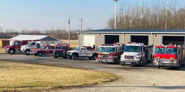 Fire trucks and emergency vehicles lined up outside a fire rescue station.