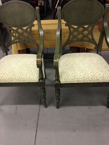 Pair of vintage wooden chairs with patterned cushioned seats and decorative backs.